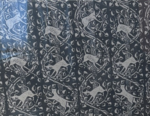 A Peggy Angus wallpaper design: stags and deer among trees and foliage, white on slate blue