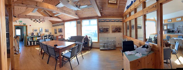 The research room: tables and chairs, shelves of files and archive boxes, framed pictures on the walls