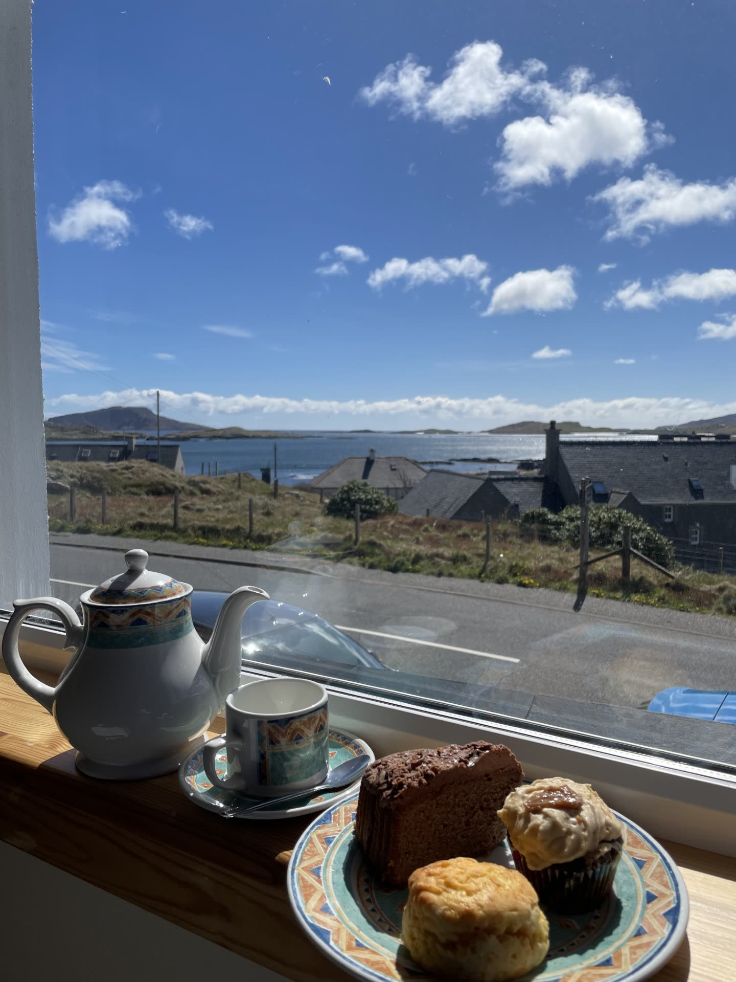 Tea and scones on a windowsill looking out over the bay
